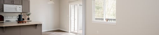 A spacious living room with a kitchenette and a window.