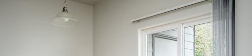 A room with a sliding door leading to a balcony.