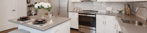 a kitchen with white cabinets and stainless steel appliances