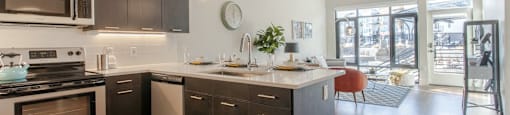 Living room and kitchen with wood flooringat Delo Apartments, Louisville, Colorado