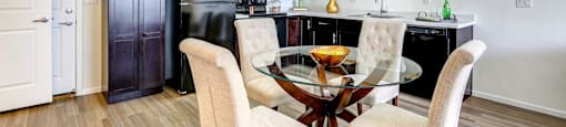 Kitchen with dark wood cabinets and dining area at Enclave Apartments, Henderson, CO, 80640