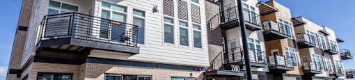 Building with balconies and a sidewalk at Delo Apartments, Louisville