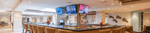 the lobby of a restaurant with a bar and chairs