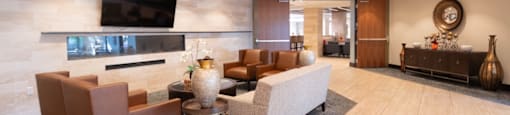 the lobby of a hotel with couches and a television