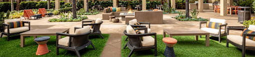 a courtyard with tables and chairs and palm trees