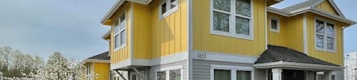 A two-story house with a yellow and gray exterior.