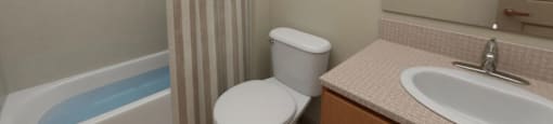 a bathroom with a toilet sink and bathtub at The Aries at Bitter Lake Apartments, Seattle