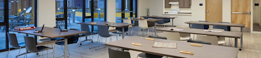 a large classroom with tables and chairs and a kitchen at The Aries at Bitter Lake Apartments, Seattle, WA