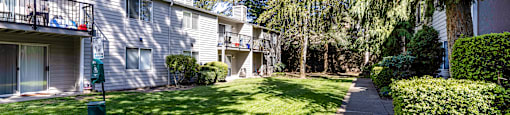 A sunny day in a well-kept apartment complex with a pathway leading to the buildings.