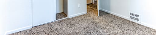 A room with a carpeted floor and a white ceiling with a light fixture.