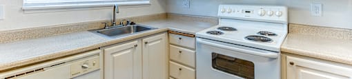 A kitchen with white appliances and cabinets.