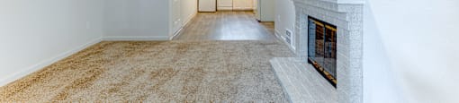 A long, empty hallway with a fireplace on the right side.