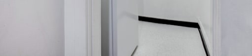 A white refrigerator is in a small kitchen.