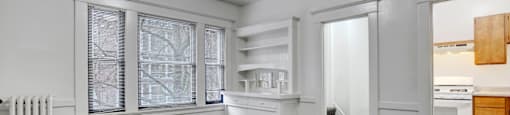 A white room with a grey carpet and a white radiator.