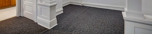 A room with a carpeted floor and white walls.