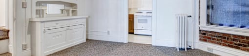 A white kitchen with a white fridge and a white oven.