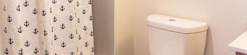 a bathroom with a toilet and a shower curtain at Arbora Court, Seattle, Washington
