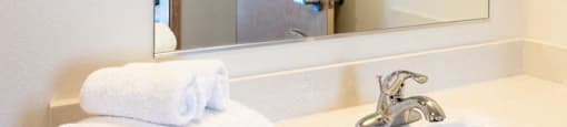 a bathroom with a sink and a large mirror at Arbora Court, Seattle, WA