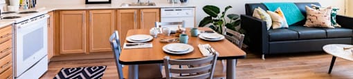 a living room with a kitchen and a dining table at Arbora Court, Seattle, WA