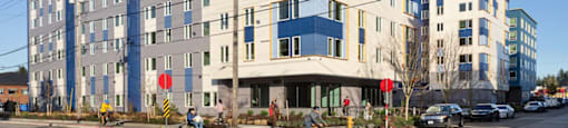 a large building on the corner of a city street at The Aries at Bitter Lake Apartments, Seattle, Washington