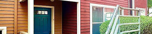 A house with a blue door and a red siding.