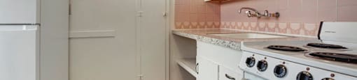 A kitchen with white appliances and cabinets.