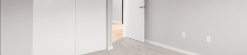 A room with a carpeted floor and a white door.