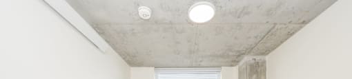 A room with a window and a concrete pillar.