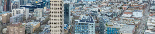 A cityscape with a mix of modern and older buildings under a clear sky.