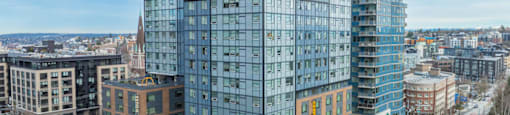 A modern glass building stands tall in a cityscape.