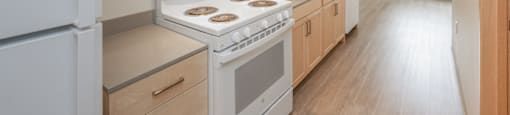 A kitchen with a white fridge, stove and oven.