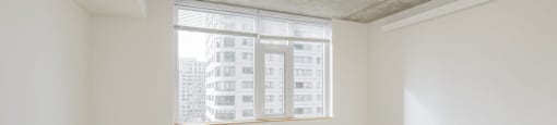 A room with a window and a ceiling fan.
