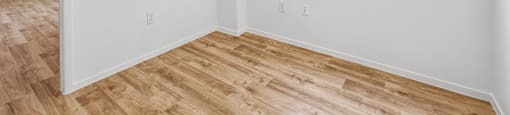 A room with a window and wooden flooring.