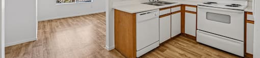 A kitchen with white appliances and wooden cabinets.