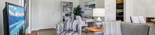 A living room with a grey couch, a chair, a coffee table, and a television at Birnam Wood Apartments, Monroeville, PA, 15146