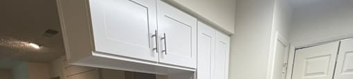 a kitchen with white cabinets and granite counter tops