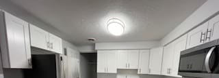 a kitchen with white cabinets and stainless steel appliances at Lavale Apartments, Monroeville