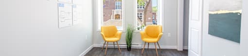 Rent in Winnipeg: a living room with two yellow chairs and a rug