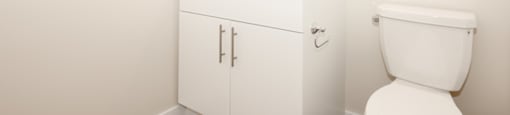 A white bathroom with a toilet, sink, and medicine cabinet.