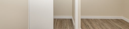 A white closet with a door and a shelf.