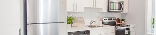 Winnipeg Apartments for rent: a renovated kitchen with white cabinets and stainless steel appliances