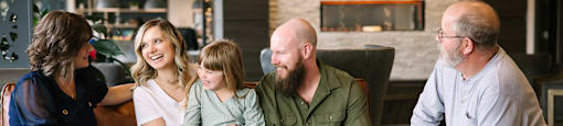 a family sits on a couch in a hotel lobby  at Harbor Heights 55+ Community, Washington