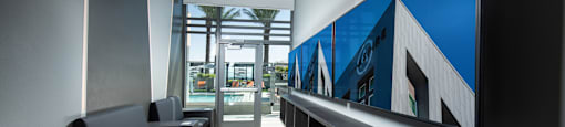 a view down the length of the lobby of a building with black couches and a large