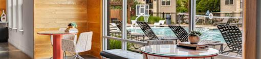 a dining area with tables and chairs next to a pool