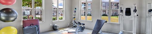 a workout room with weights and cardio equipment at the grove apartments