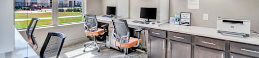 an office with two desks and chairs and a window