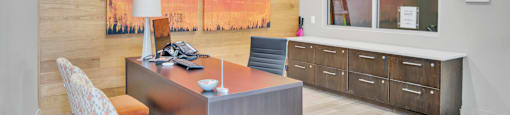 a home office with a desk and a large painting on the wall
