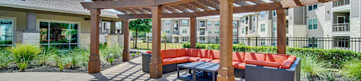 a furnished patio with a pergola and a table