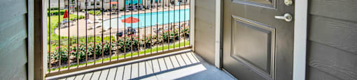 an open door to a balcony with a swimming pool