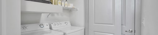 a small laundry room with white appliances and a white door